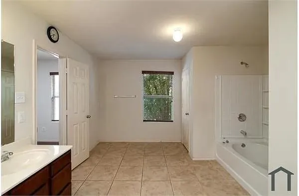 a spacious bathroom with a bathtub shower and sink