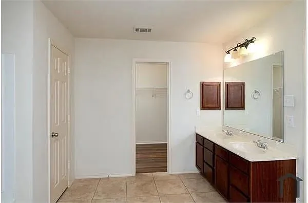 a bathroom with a sink a double vanity and a mirror