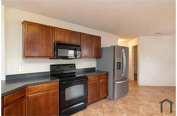 a kitchen with granite countertop a refrigerator stove and microwave