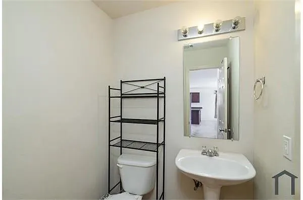 a bathroom with a sink toilet and mirror