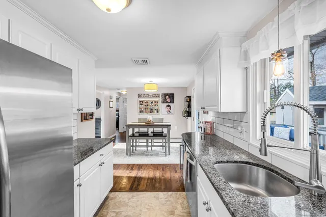a kitchen with granite countertop a sink and a refrigerator