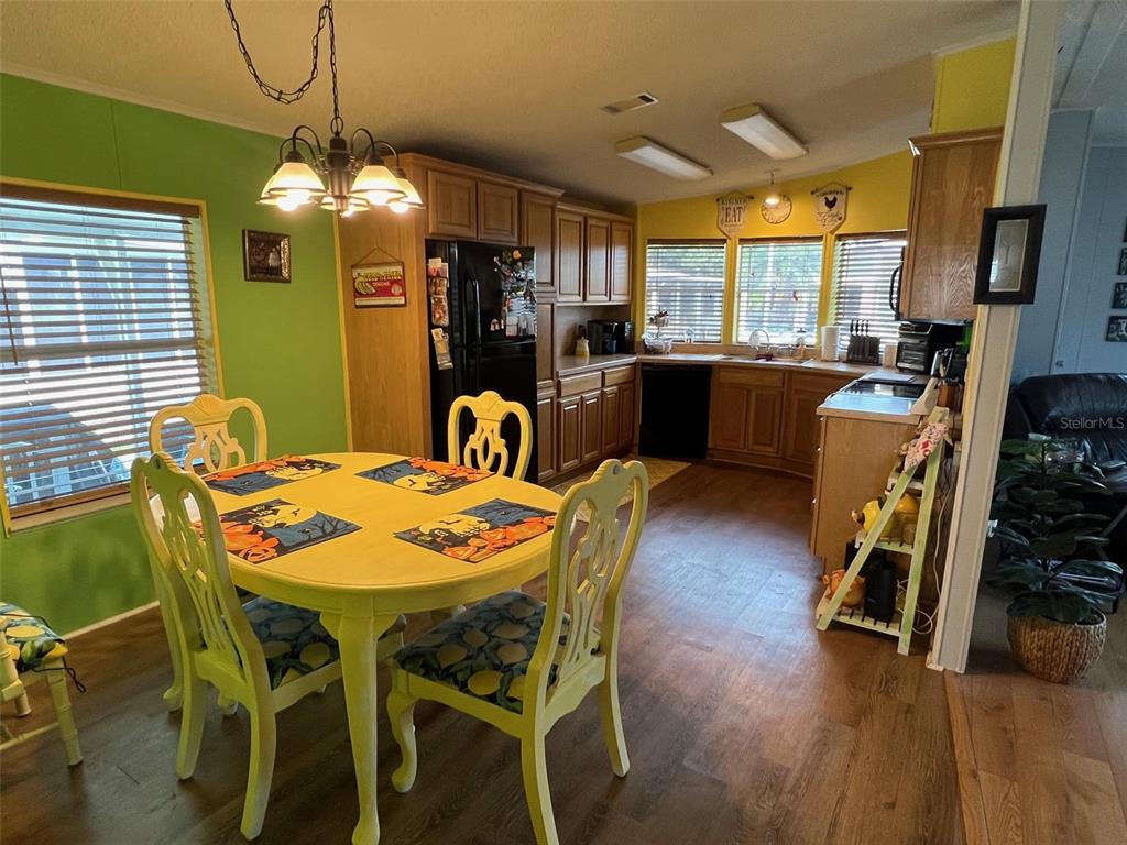 1001 Starkey Road, Unit 758 Largo, FL 33771 - Photo 14 of 37 a dining room with furniture a chandelier and wooden floor