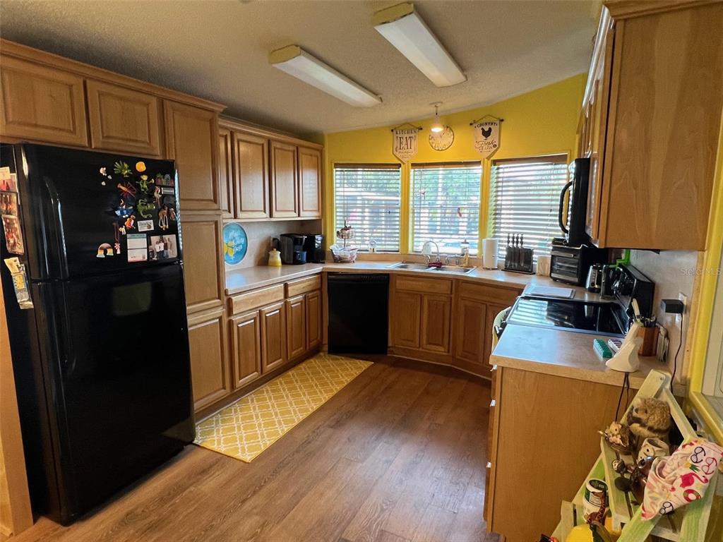 1001 Starkey Road, Unit 758 Largo, FL 33771 - Photo 15 of 37 a kitchen with sink a refrigerator and wooden cabinets