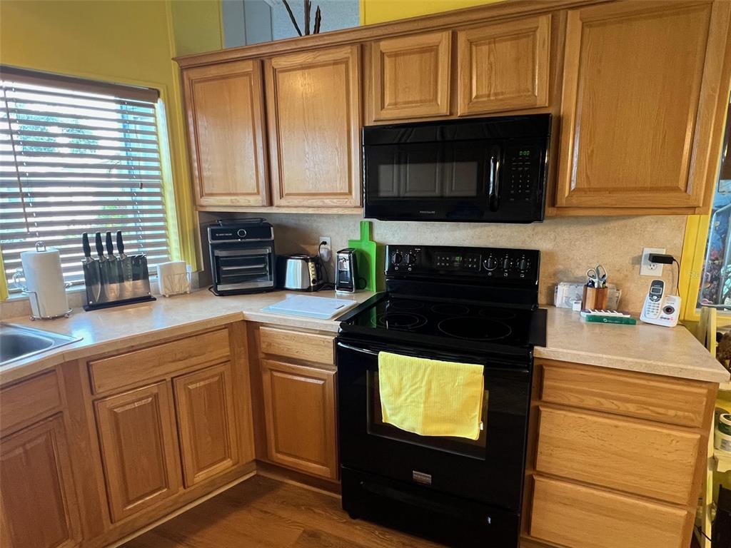 1001 Starkey Road, Unit 758 Largo, FL 33771 - Photo 18 of 37 a kitchen with stainless steel appliances granite countertop a stove a microwave and a sink