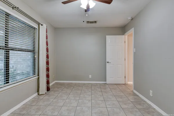an empty room with chandelier fan