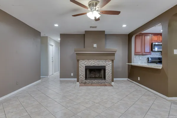 a view of an empty room with a fireplace and a window