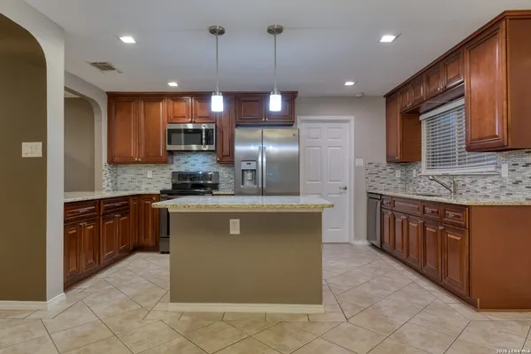 a kitchen with granite countertop stainless steel appliances and wooden cabinets