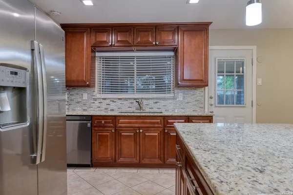 a kitchen with a stove a sink and a wooden cabinets