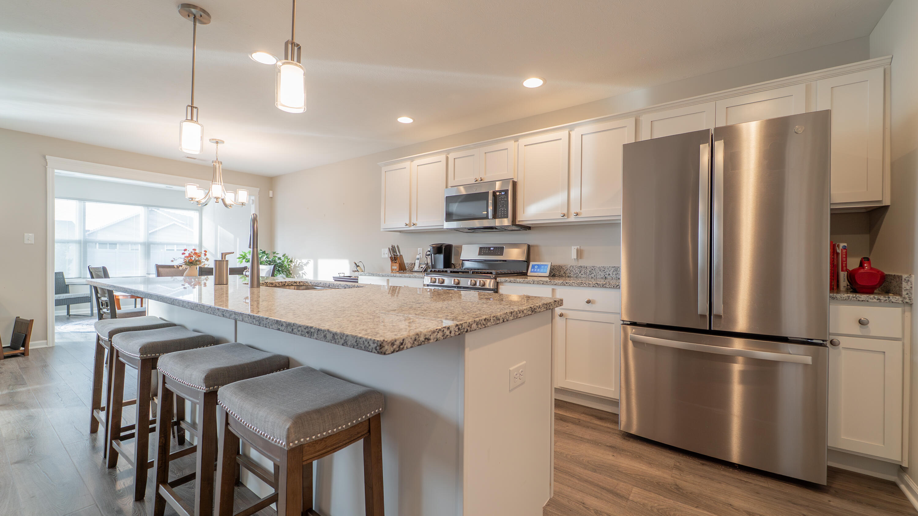 11792 Rhode Island Street Crown Point, IN 46307 - Photo 11 of 30 a kitchen with stainless steel appliances granite countertop a refrigerator a sink dishwasher a stove and a refrigerator with wooden floor