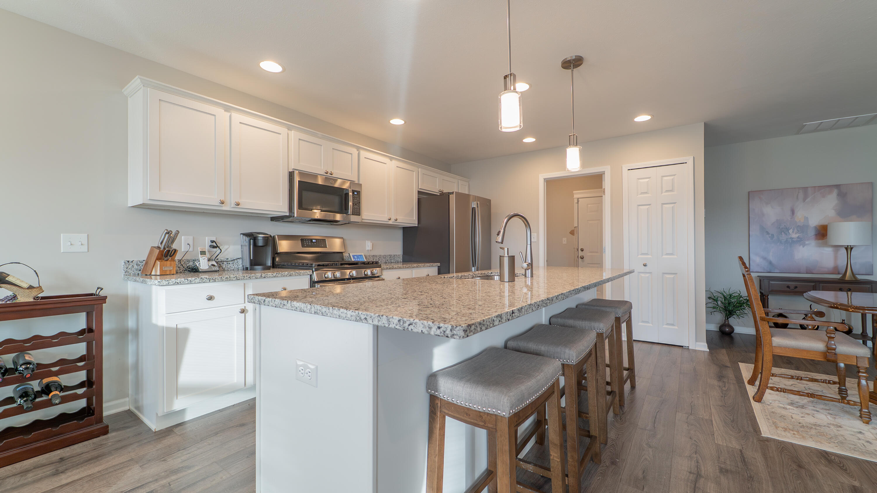 11792 Rhode Island Street Crown Point, IN 46307 - Photo 13 of 30 a kitchen with stainless steel appliances granite countertop a stove top oven a sink dishwasher a dining table and chairs with wooden floor