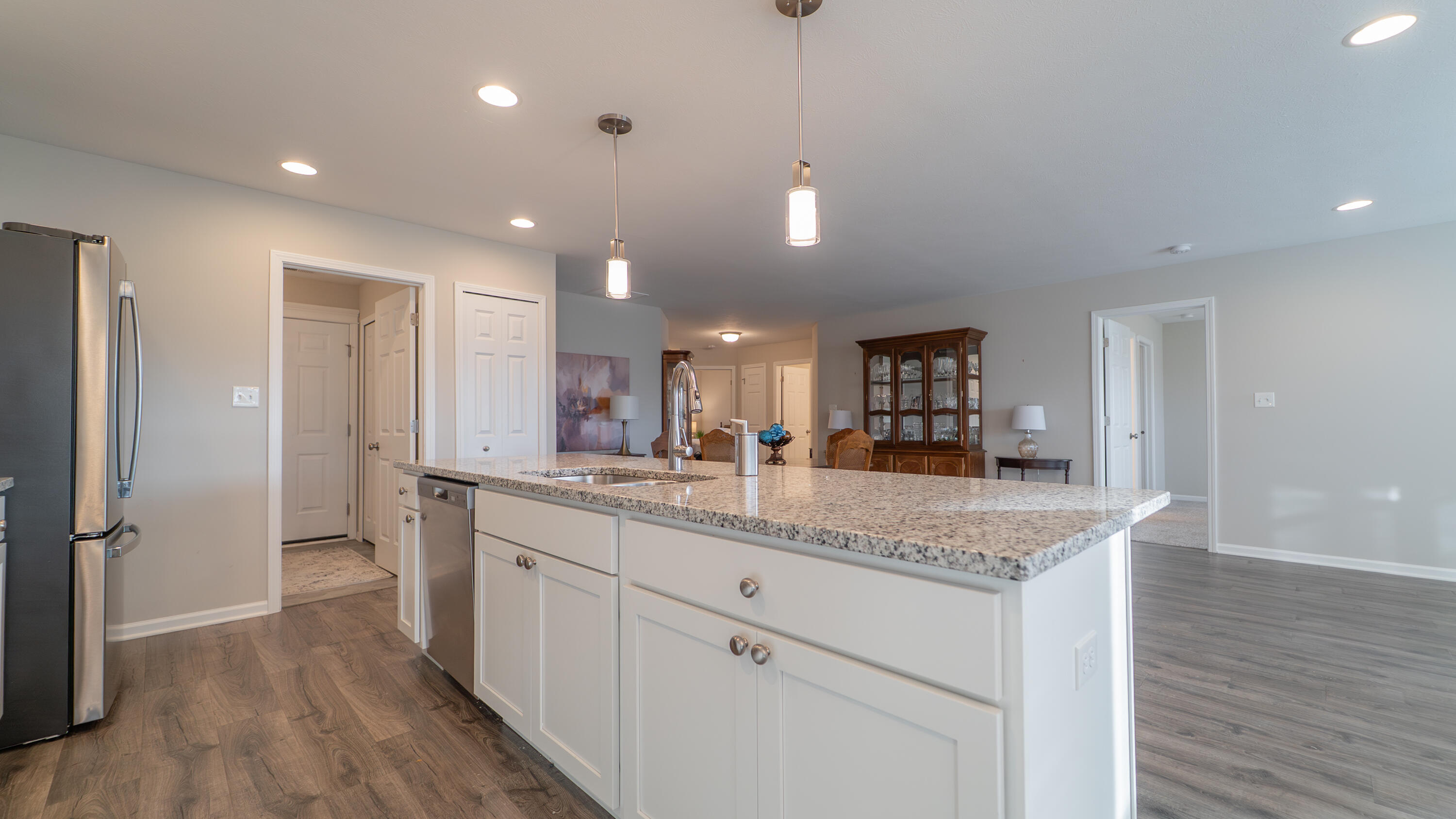 11792 Rhode Island Street Crown Point, IN 46307 - Photo 14 of 30 a kitchen with a sink dishwasher a refrigerator and white cabinets with wooden floor