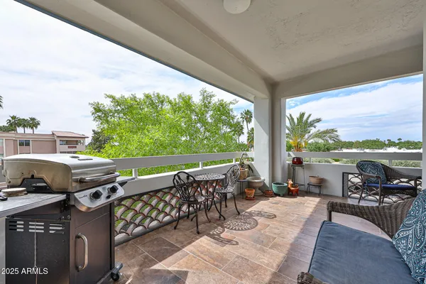 a view of a patio with lawn chairs next to a yard