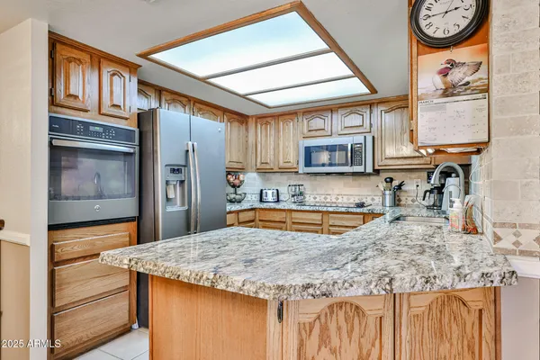 a kitchen with stainless steel appliances granite countertop a sink and a refrigerator