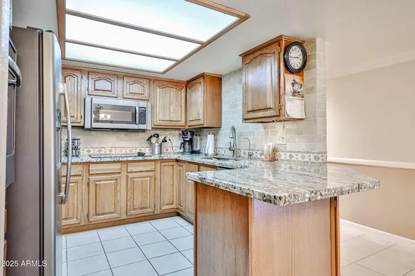 a kitchen with stainless steel appliances granite countertop a sink stove and cabinets
