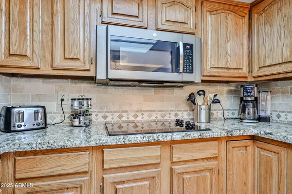 a kitchen with granite countertop stainless steel appliances white cabinets sink and a granite counter tops