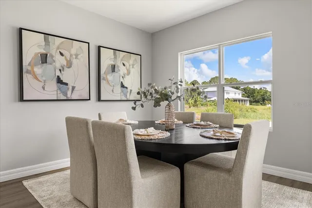 a view of a dining room with furniture large windows and wooden floor