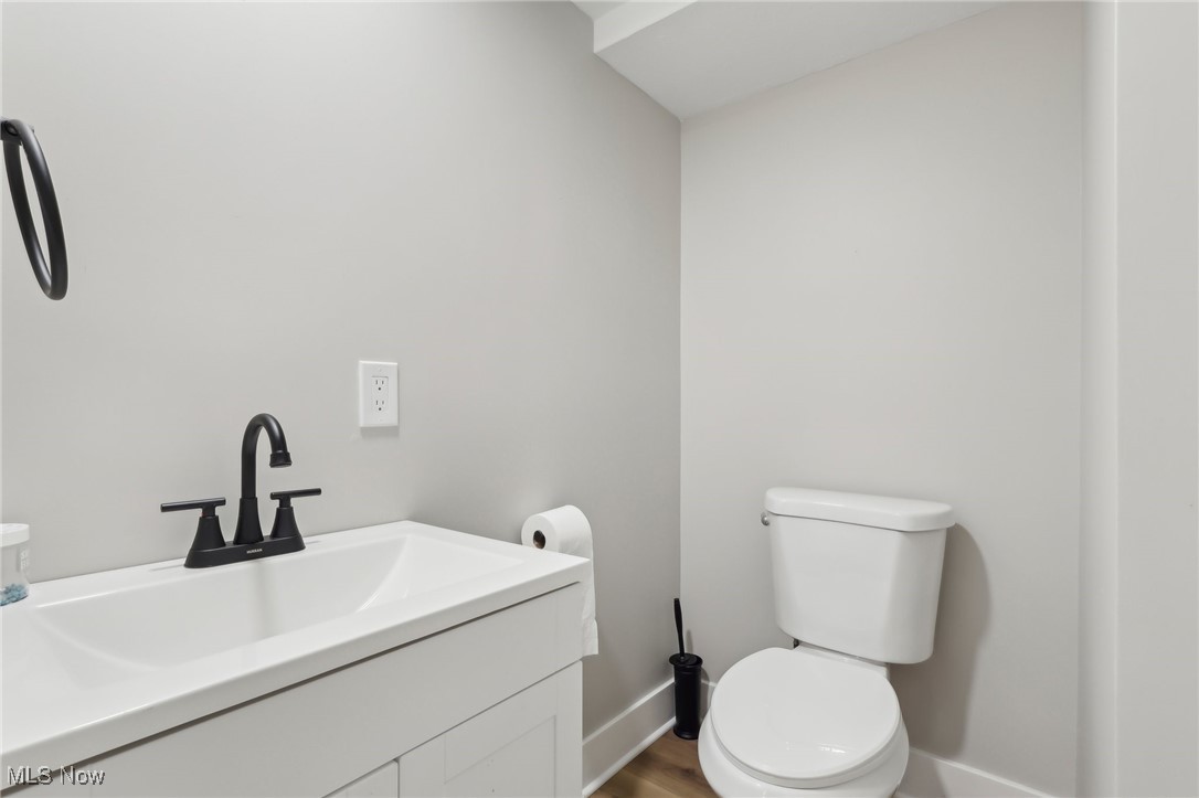 21750 Brookpark Road Cleveland, OH 44126 - Photo 18 of 30 Half bath with baseboards, toilet, wood finished floors, and vanity