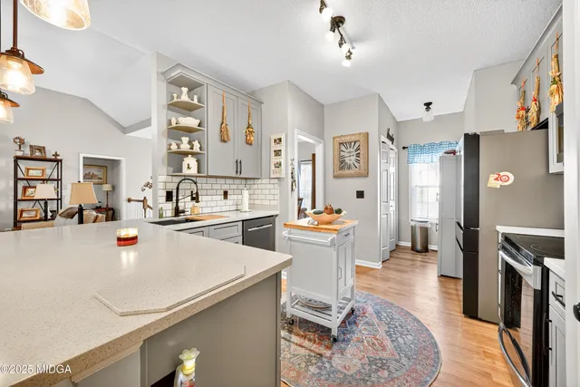a large white kitchen with a large counter top appliances and cabinets