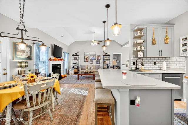 a view of a dining room and livingroom with furniture wooden floor a chandelier