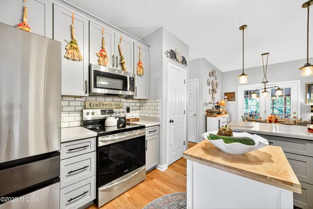 a kitchen with stainless steel appliances granite countertop a refrigerator a stove top oven a sink and dishwasher