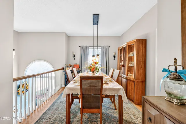 a view of a dining room with furniture a chandelier and wooden floor