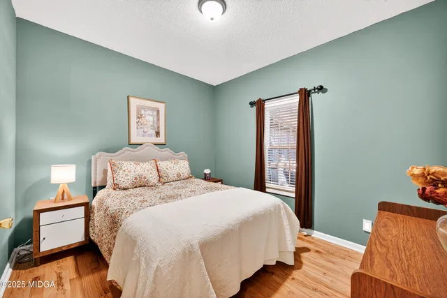 a bedroom with a bed and a lamp on dresser