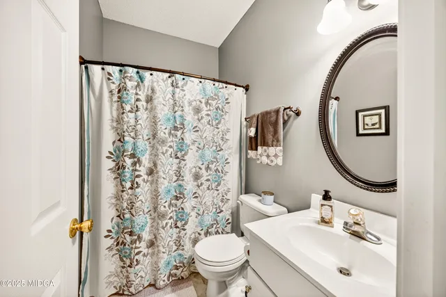 a bathroom with a sink mirror and a toilet