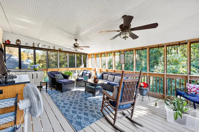 a living room with furniture floor to ceiling window and wooden floor