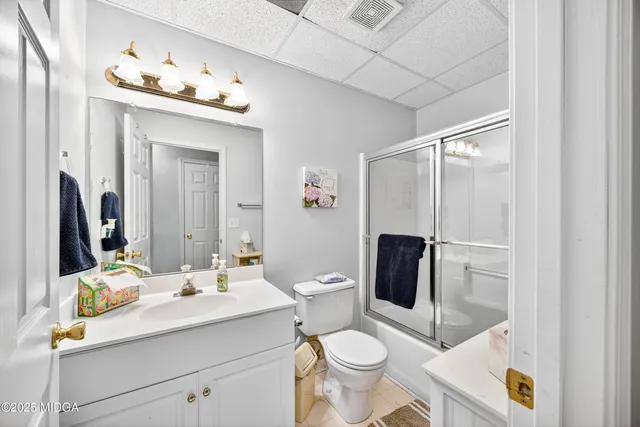 a bathroom with a toilet sink double vanity and mirror
