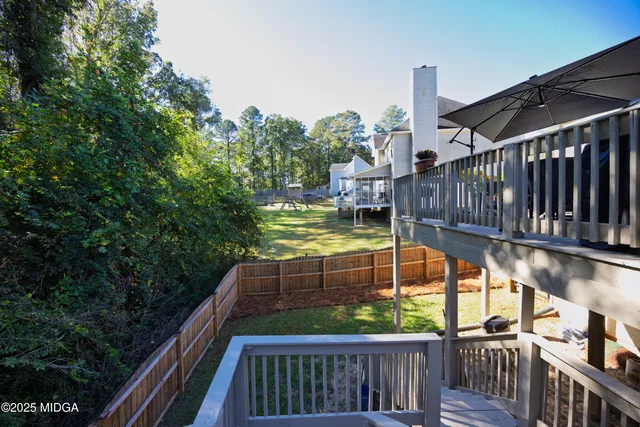 a view of balcony with wooden fence and trees