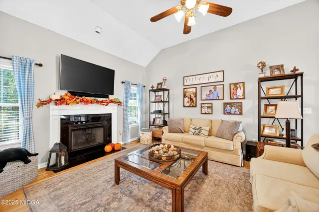 a living room with furniture a flat screen tv and a fireplace