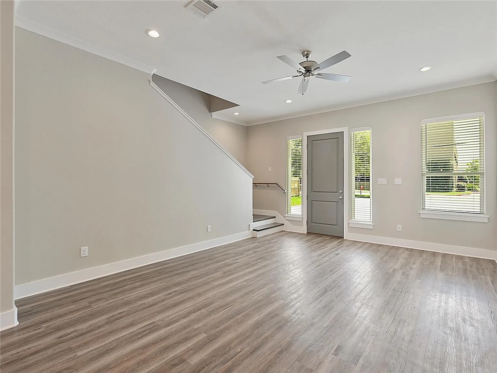 407 Ash Street College Station, TX 77840 - Photo 14 of 14 Unfurnished living room with crown molding, recessed lighting, wood finished floors, stairway, and ceiling fan