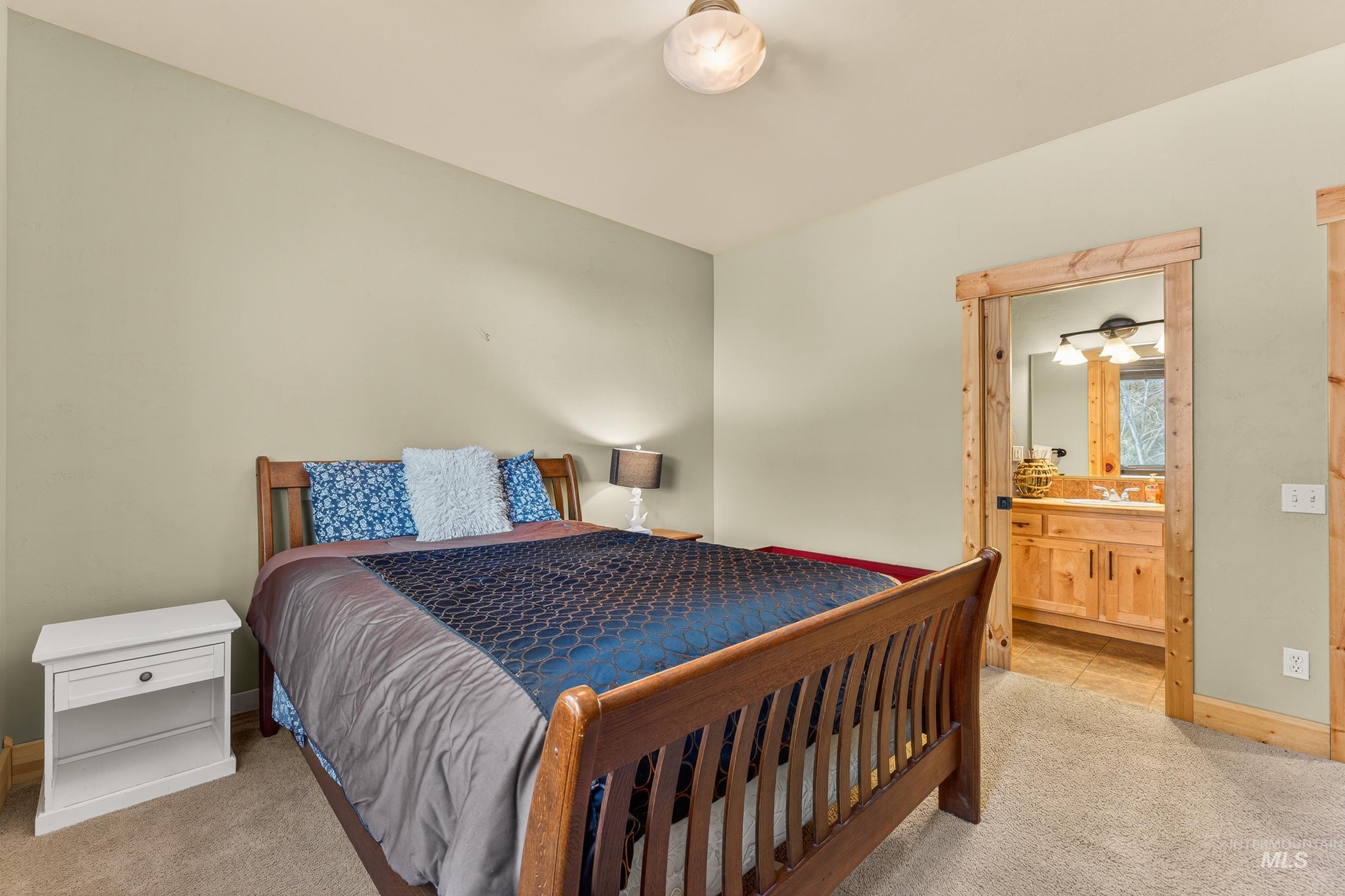 722 Lick Creek Road, Unit 8 McCall, ID 83638 - Photo 22 of 50 Bedroom with light carpet and ensuite bath