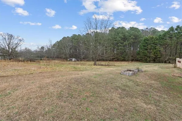 a view of a field with trees in the background