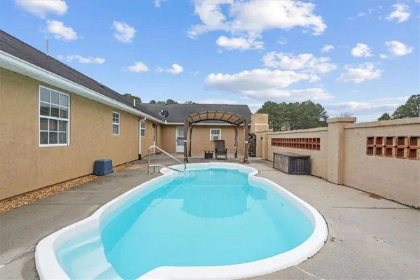 a view of a house with swimming pool and sitting area