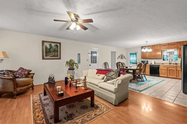 a living room with furniture kitchen view and a window