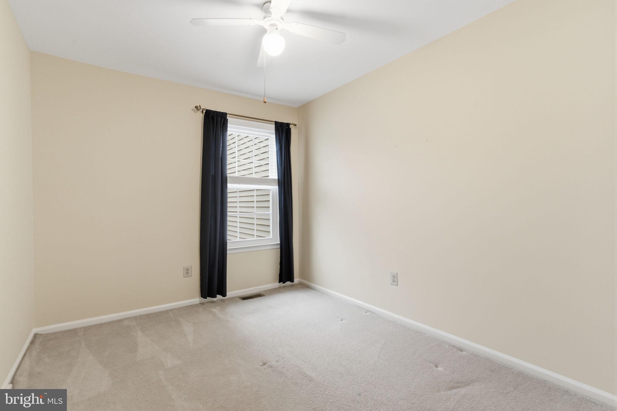 100 Bishops Gate Lane Doylestown, PA 18901 - Photo 11 of 33 an empty room with a chandelier fan and windows