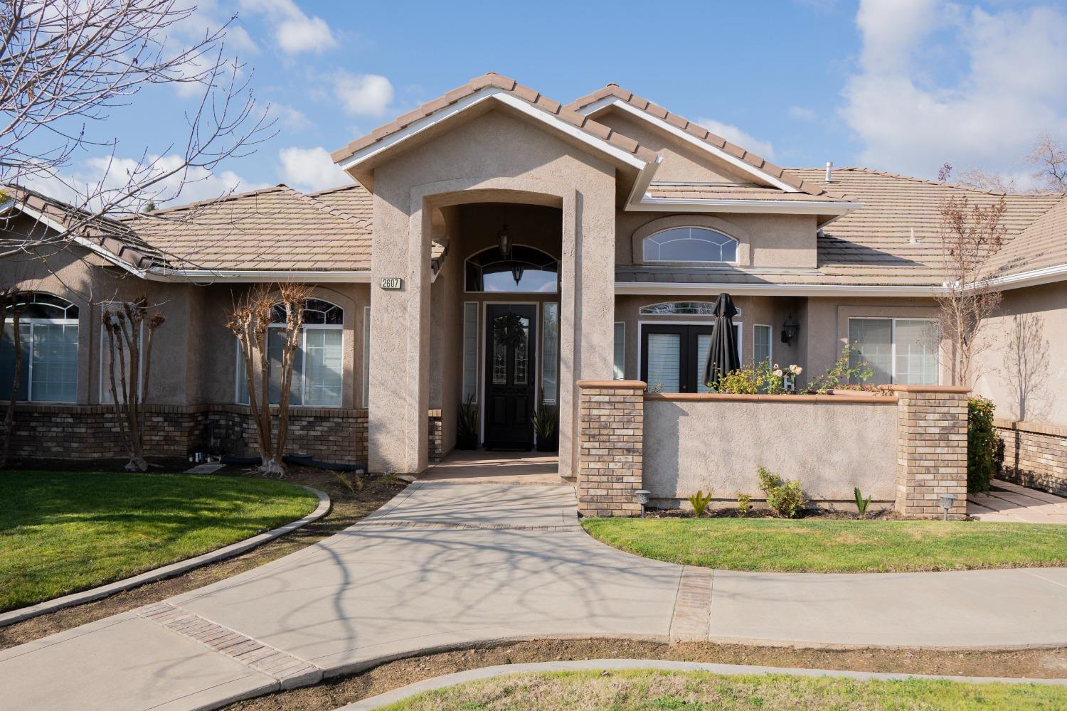 a view of a white house with large windows and a yard