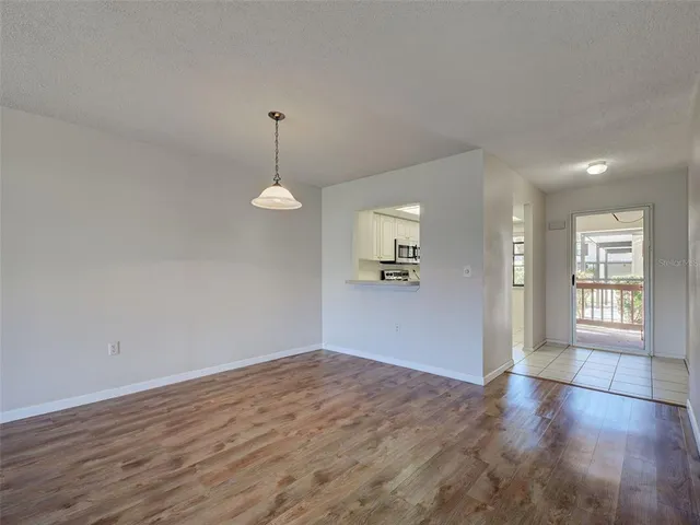 a view of an empty room window and wooden floor