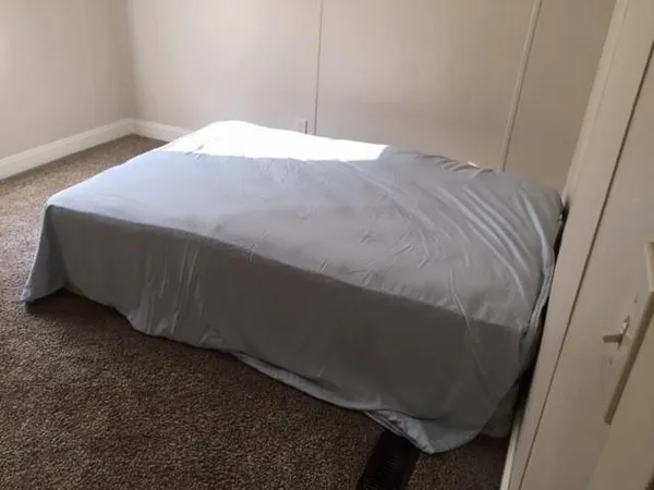 a bed sitting in a bedroom next to a window