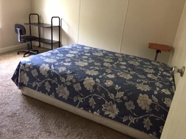 a bed sitting in a bedroom next to a window