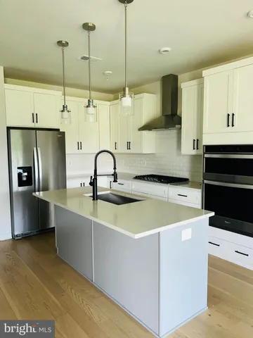 a kitchen with stainless steel appliances granite countertop a sink a stove and a refrigerator