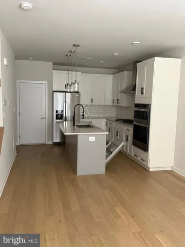 a kitchen with kitchen island a sink stove and refrigerator