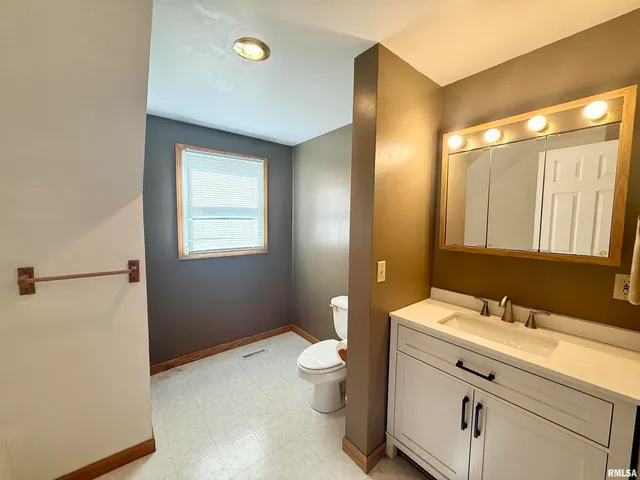 a bathroom with a double vanity sink toilet and a mirror
