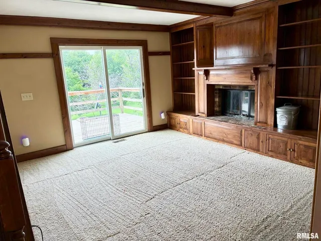 a view of empty room with a fireplace and window