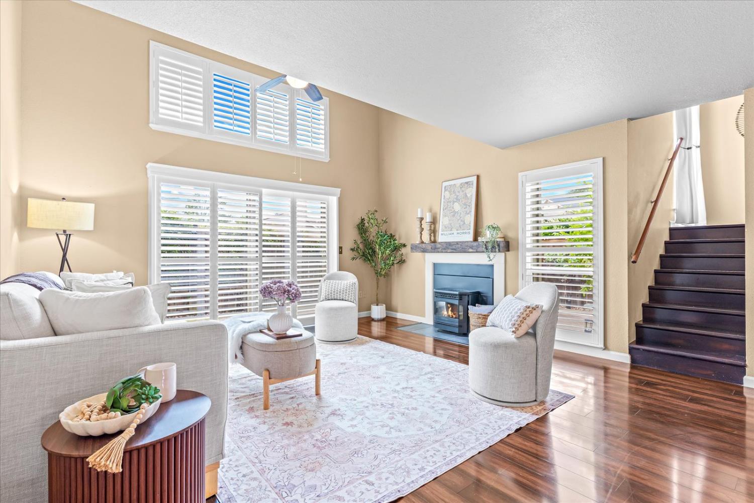 a living room with furniture a fireplace and a potted plant