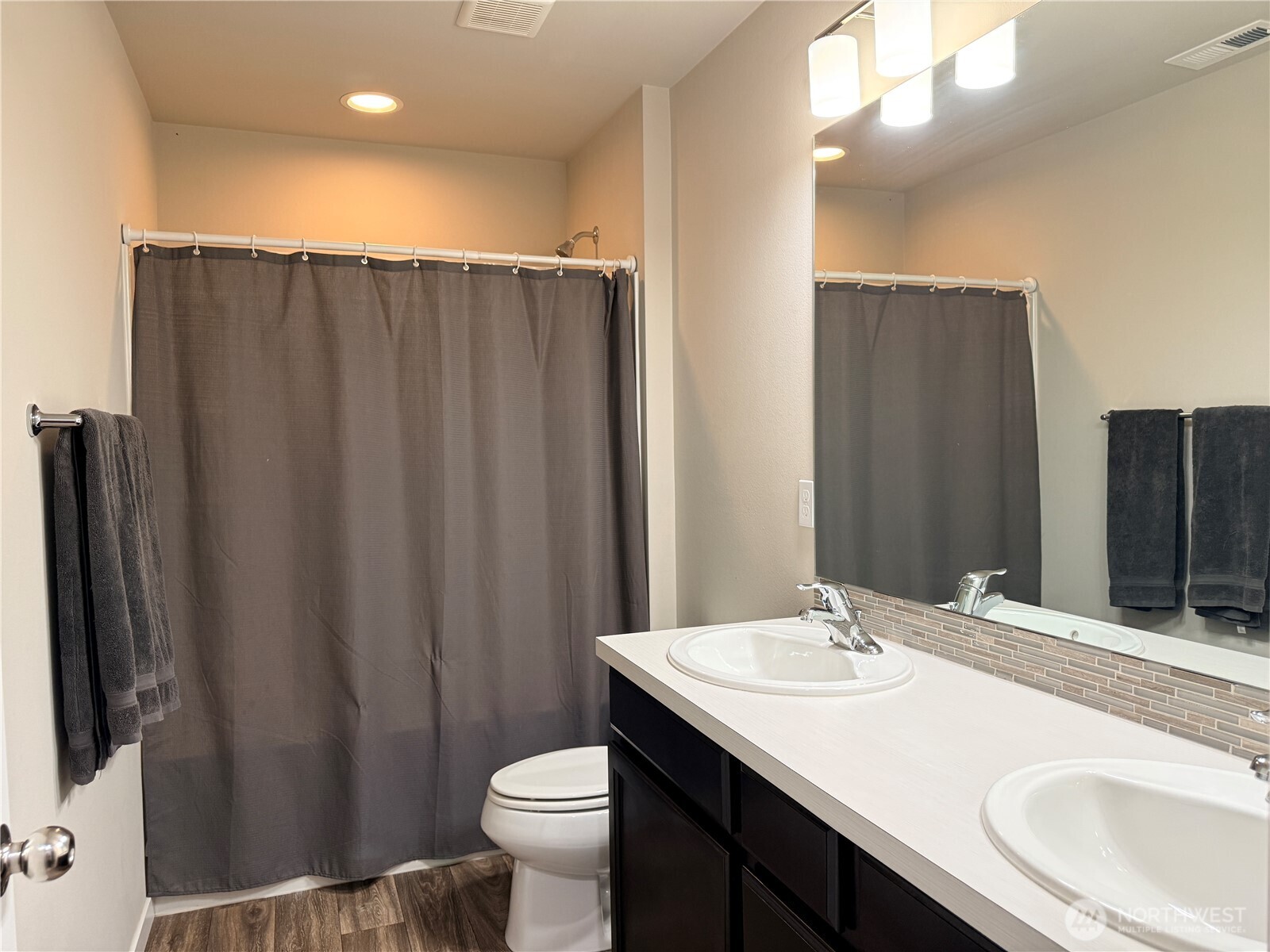 4880 Limerick Drive Southwest Port Orchard, WA 98367 - Photo 31 of 38 a bathroom with a sink a toilet a mirror and shower curtain
