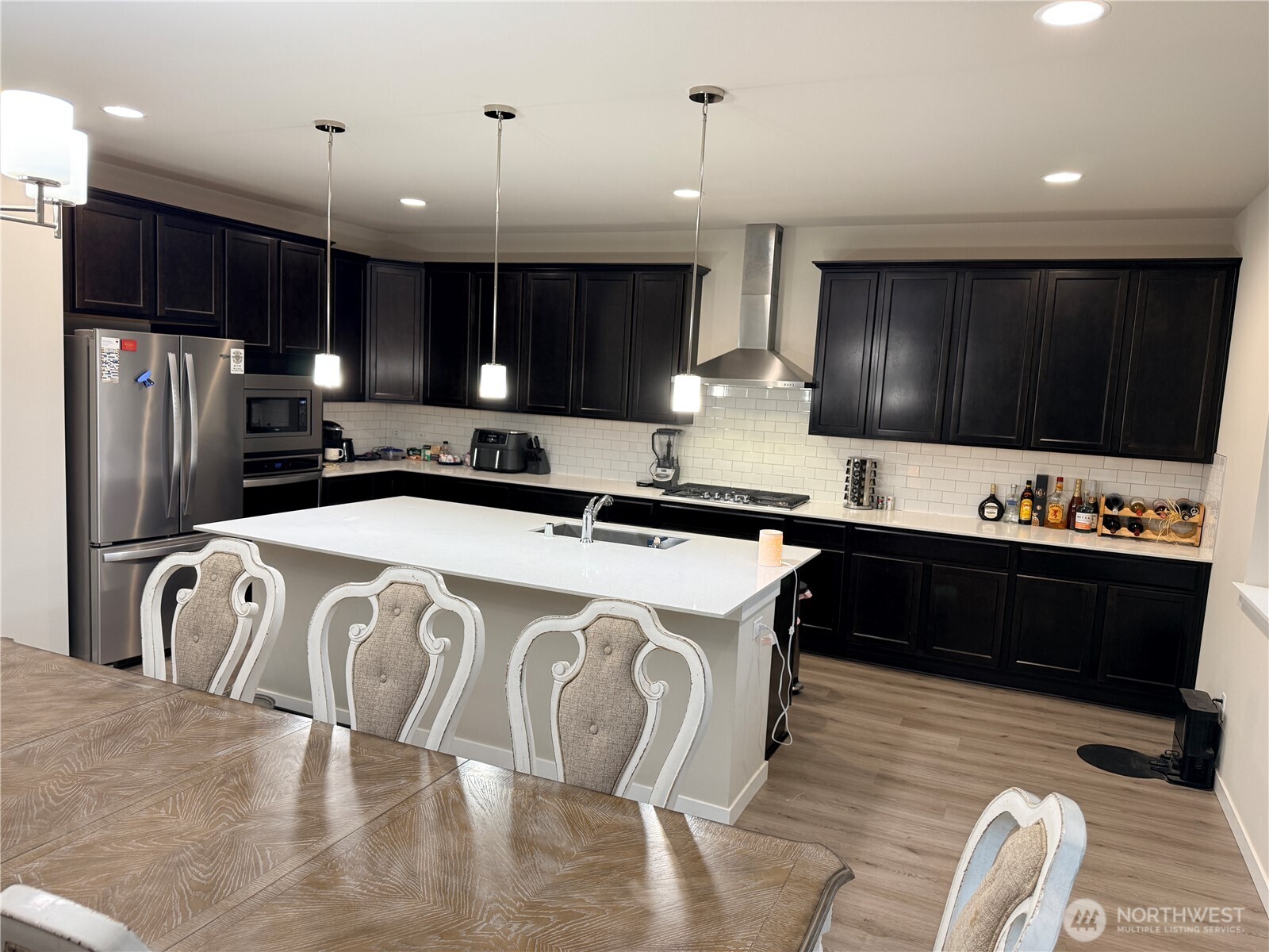 4880 Limerick Drive Southwest Port Orchard, WA 98367 - Photo 10 of 38 a kitchen with stainless steel appliances granite countertop a refrigerator a sink a stove and a microwave with wooden floor