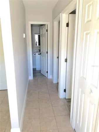 a view of a hallway with wooden floor and closet area
