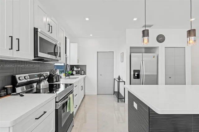 a kitchen with stainless steel appliances a stove microwave and a refrigerator